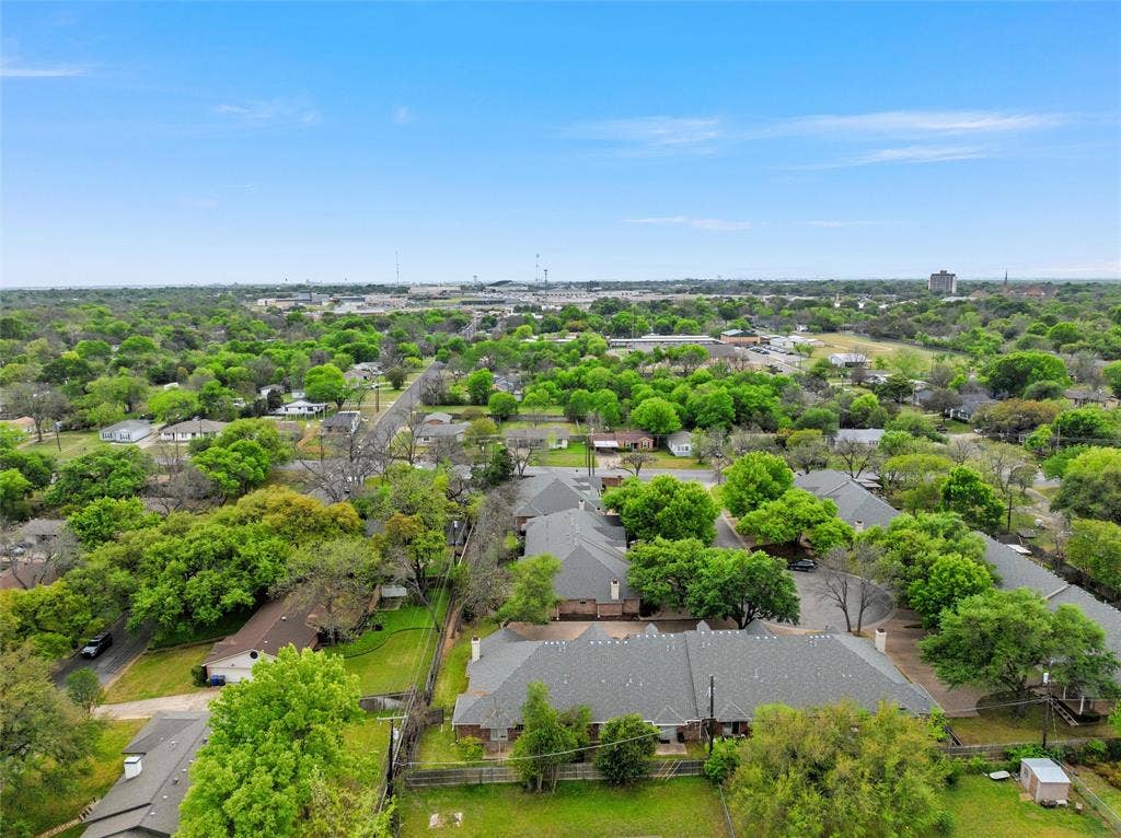 201 Pecan Village Circle, Waco, TX 76710 Aerial perspective of the property featuring a multi-pitched shingled roofline and mature canopy trees
