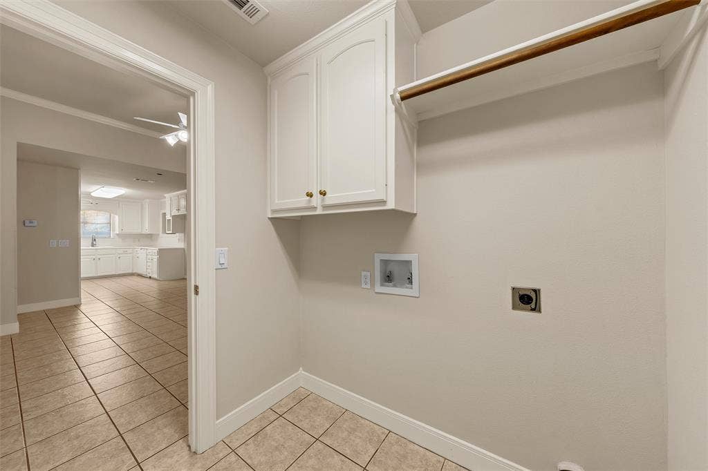201 Pecan Village Circle, Waco, TX 76710 Utility area featuring neutral tile flooring, white shaker-style cabinetry, and a built-in hanging rod