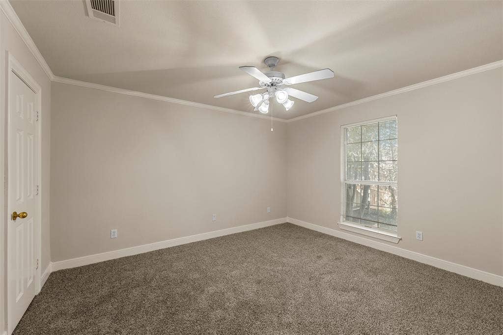 201 Pecan Village Circle, Waco, TX 76710 Neutral-toned interior featuring wall-to-wall carpeting, a multi-blade ceiling fan with integrated lighting, and a single-hung window with a grid pattern
