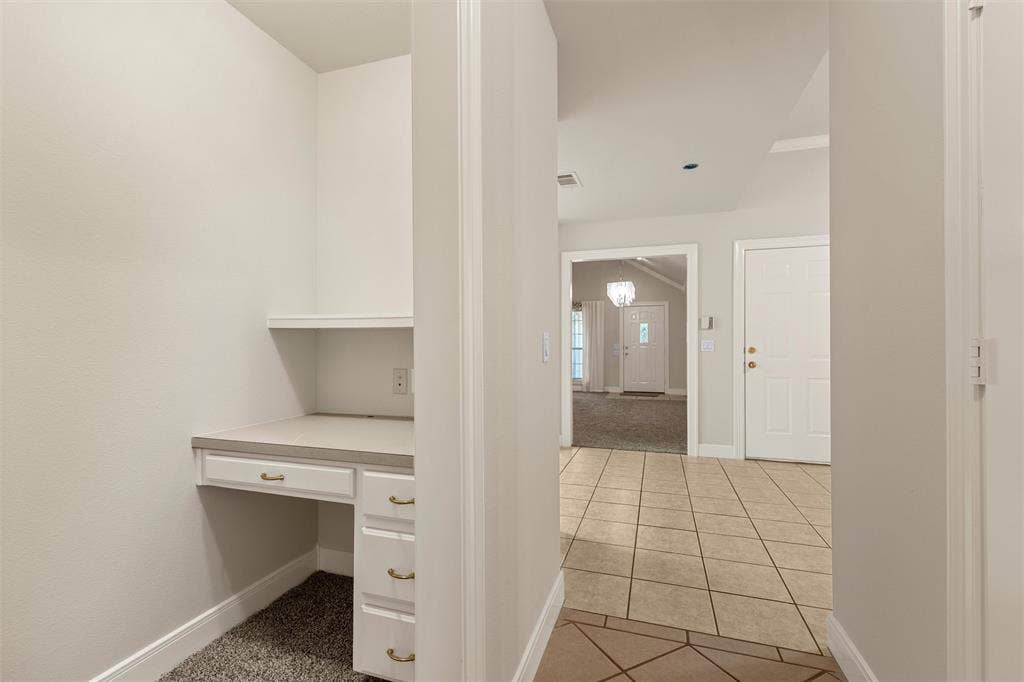 201 Pecan Village Circle, Waco, TX 76710 Built-in desk featuring white cabinetry, drawers, and a solid-surface countertop with an integrated upper shelf