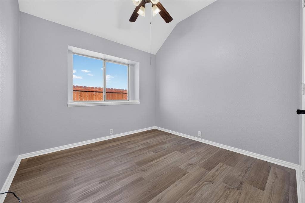 701 Abbey Lane, Midlothian, TX 76065 Interior space featuring vaulted ceilings, wood-finish flooring, and a ceiling fan with integrated lighting