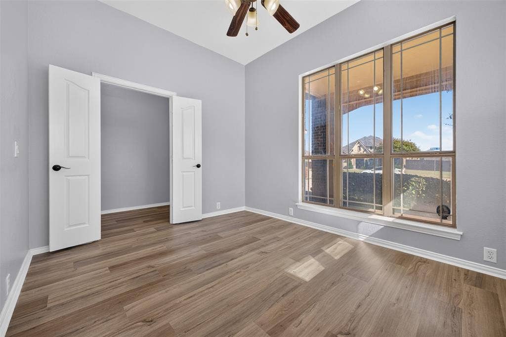701 Abbey Lane, Midlothian, TX 76065 Wood-finish flooring, vaulted ceiling, large grid-pattern windows, and dual-panel interior doors