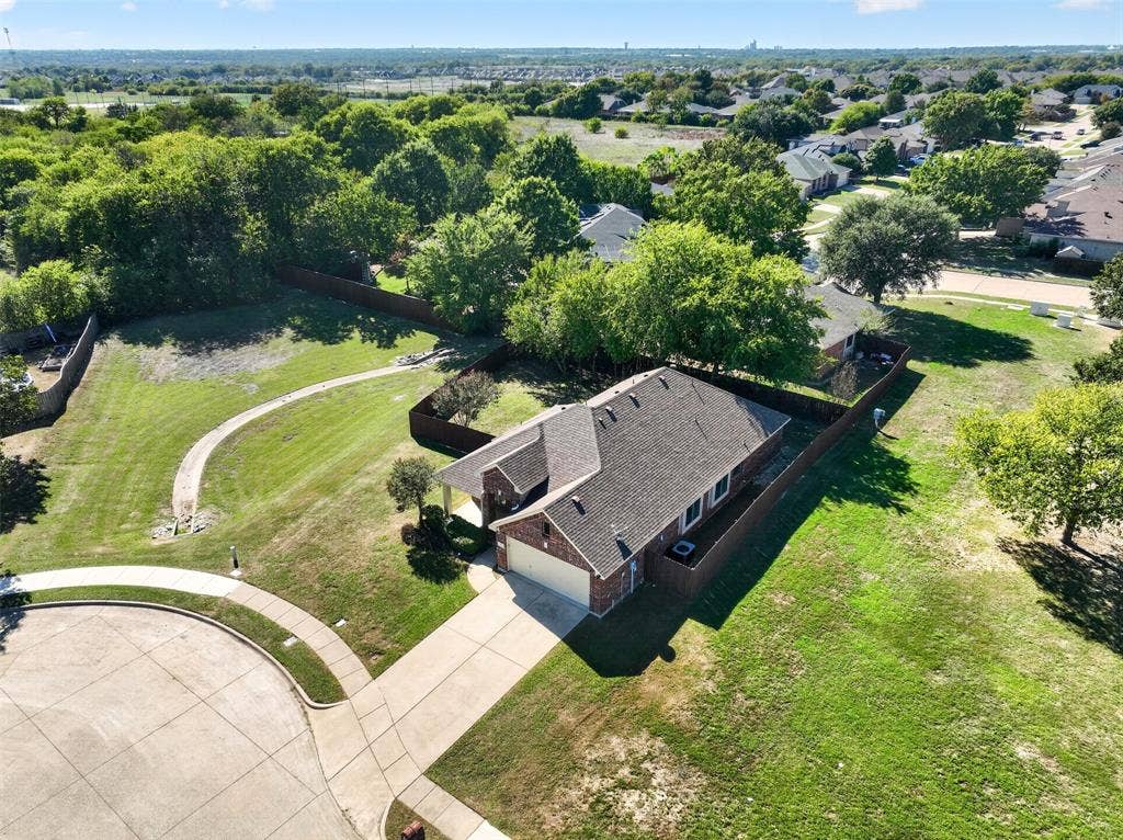 701 Abbey Lane, Midlothian, TX 76065 Single-story brick residence with an attached two-car garage, concrete driveway, wood privacy fencing, and expansive grounds