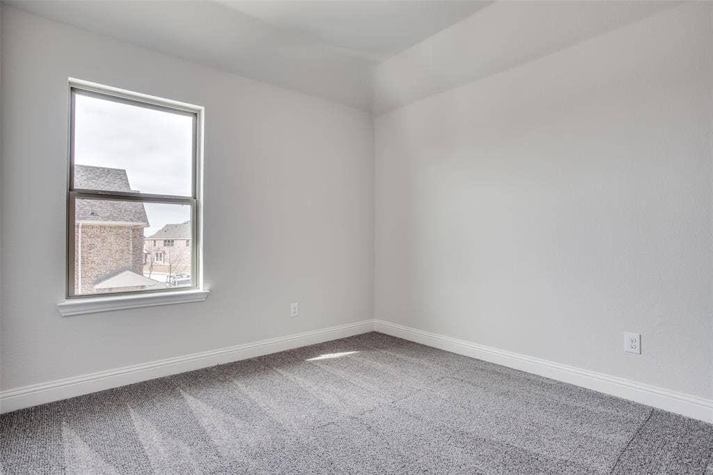 6341 Fortuna Lane, McKinney, TX 75070 Neutral interior space featuring textured wall-to-wall carpeting, crisp white walls, and a single-hung window with a deep sill