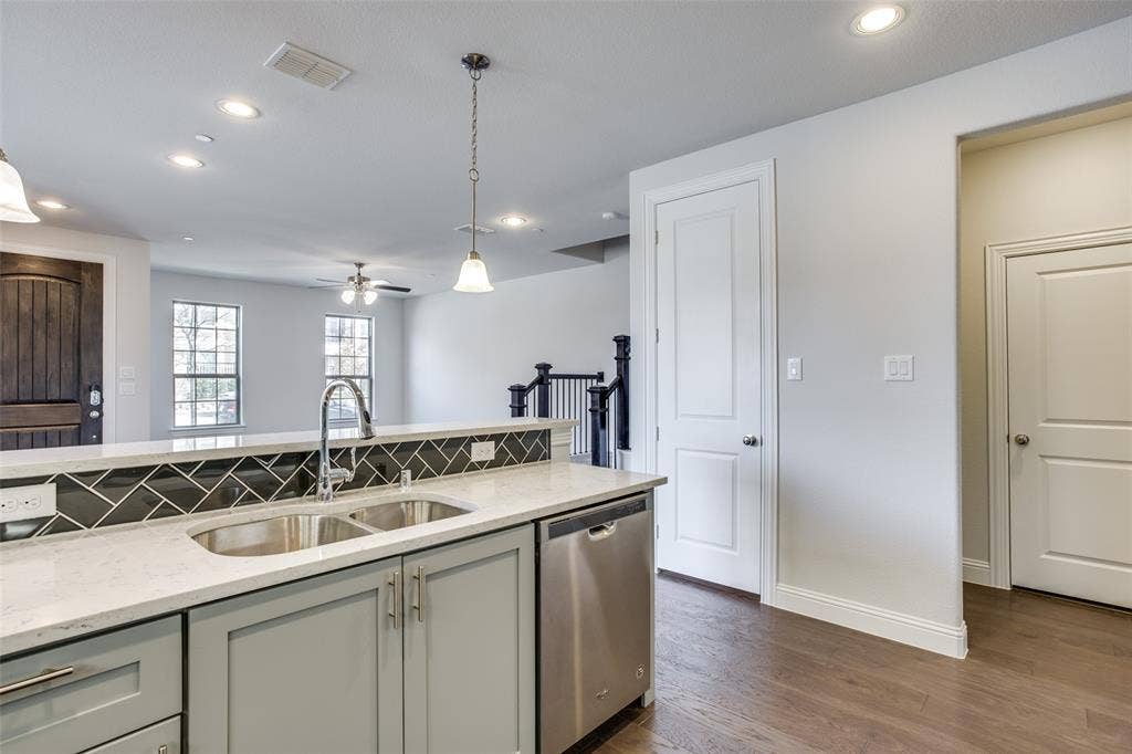 6341 Fortuna Lane, McKinney, TX 75070 Kitchen featuring a stone-look countertop, chevron-pattern tile backsplash, stainless steel dishwasher, wood-finish flooring, and recessed lighting