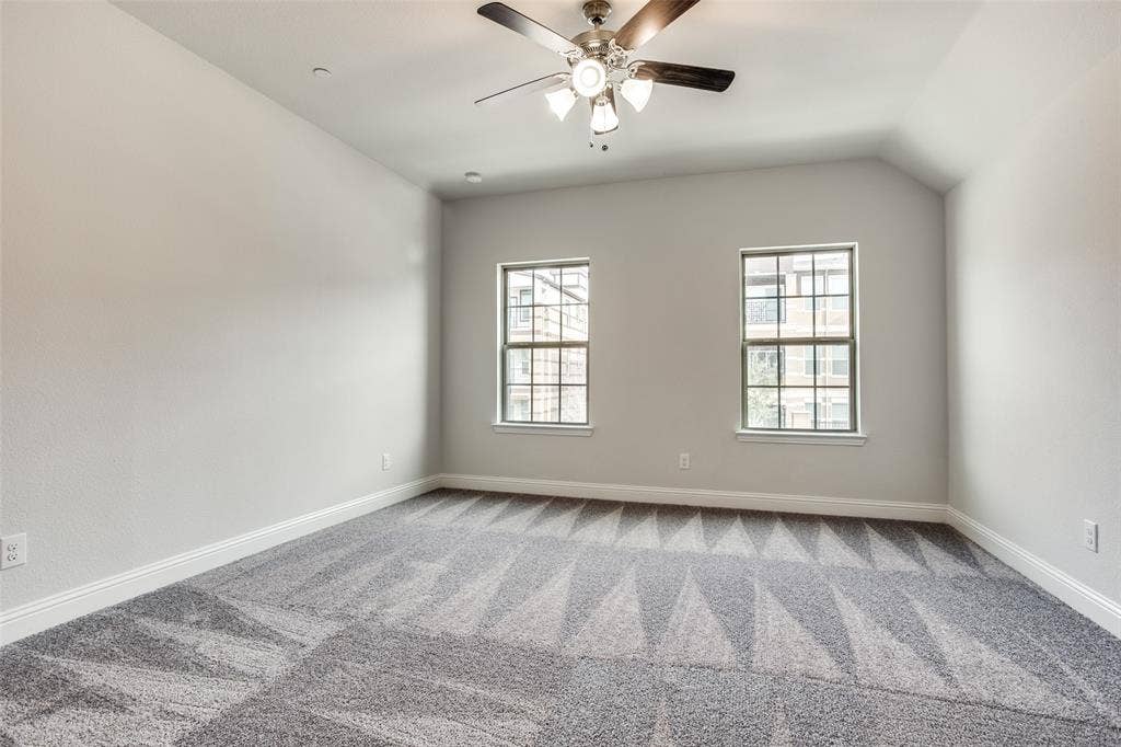 6341 Fortuna Lane, McKinney, TX 75070 Interior room featuring neutral wall tones, patterned carpeting, dual windows, and a multi-light ceiling fan
