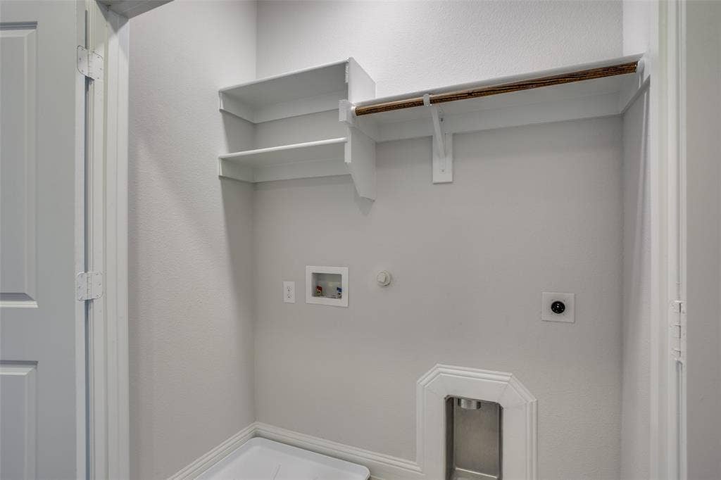 6341 Fortuna Lane, McKinney, TX 75070 Built-in white shelving with integrated hanging rod, recessed wall-mounted utility connections, and metallic recessed floor box
