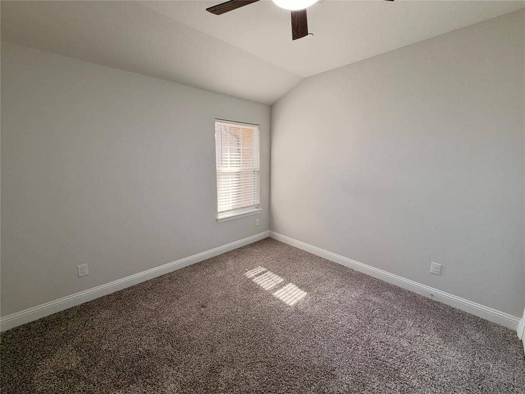 1063 Mj Brown Street, Allen, TX 75002 Vaulted ceiling with a centrally mounted ceiling fan, neutral wall finishes, plush wall-to-wall carpeting, and a single-hung window with horizontal blinds
