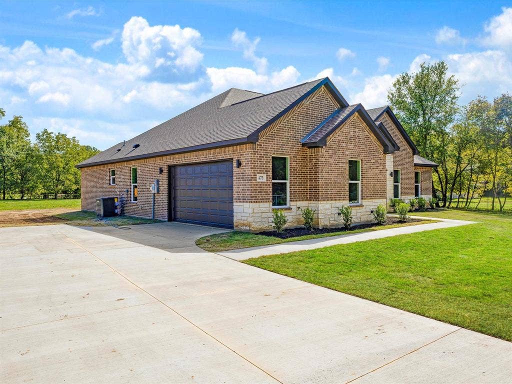 475 Loren Boyd Road, Combine, TX 75159 Single-story brick exterior featuring a multi-gabled roofline, stone veneer accents, an attached two-car garage, and concrete driveway