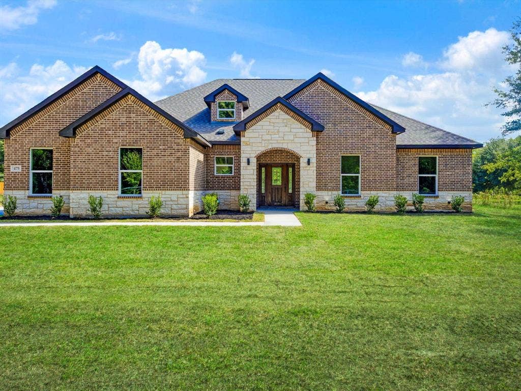 475 Loren Boyd Road, Combine, TX 75159 Brick and stone masonry exterior with a prominent arched stone entryway, multi-gable roofline, and dormer window