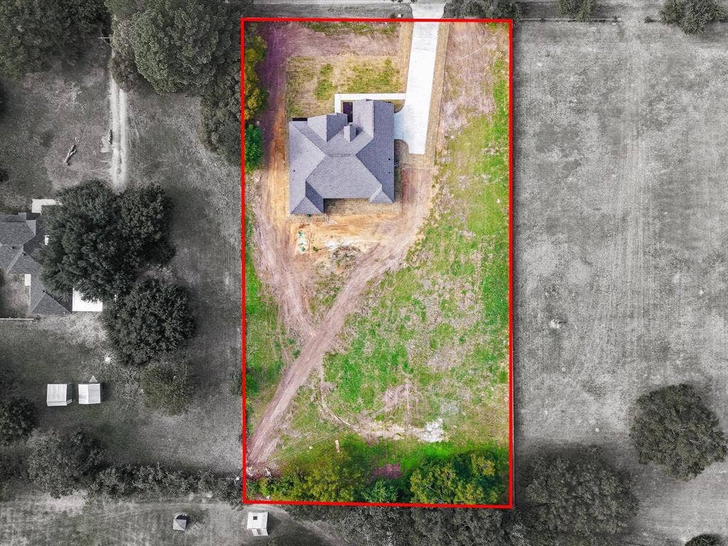 475 Loren Boyd Road, Combine, TX 75159 Aerial perspective of a detached residential structure featuring a multi-gable roof, concrete driveway, and expansive lot