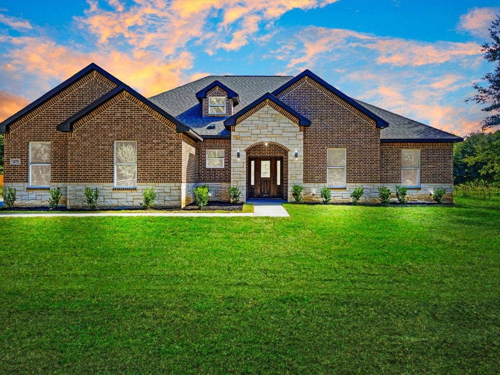 475 Loren Boyd Road, Combine, TX 75159 Exterior facade featuring a combination of red brick and light-toned stone masonry, a covered entryway with an arched stone surround, a multi-gabled roofline, and a manicured front lawn