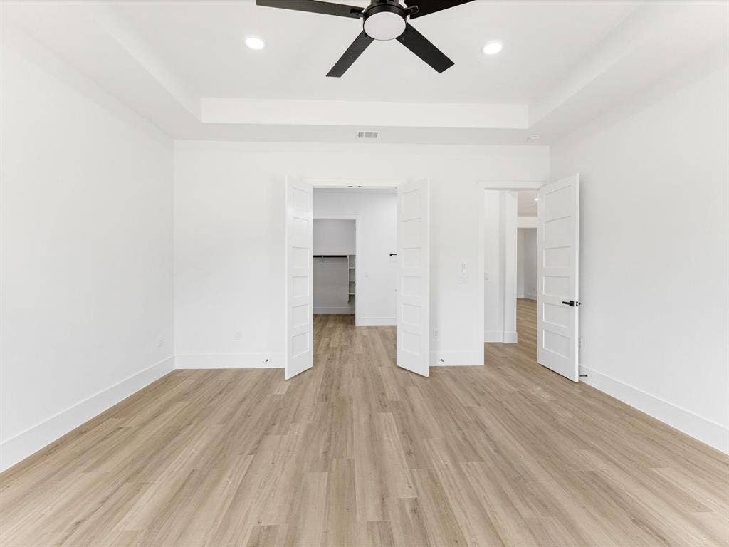 475 Loren Boyd Road, Combine, TX 75159 Tray ceiling with recessed lighting, matte black ceiling fan, wood-finish flooring, and white paneled interior doors