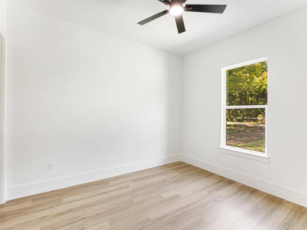 475 Loren Boyd Road, Combine, TX 75159 Neutral-toned wall finish, wood-finish flooring, single-hung window, and a matte black ceiling fan with an integrated light fixture