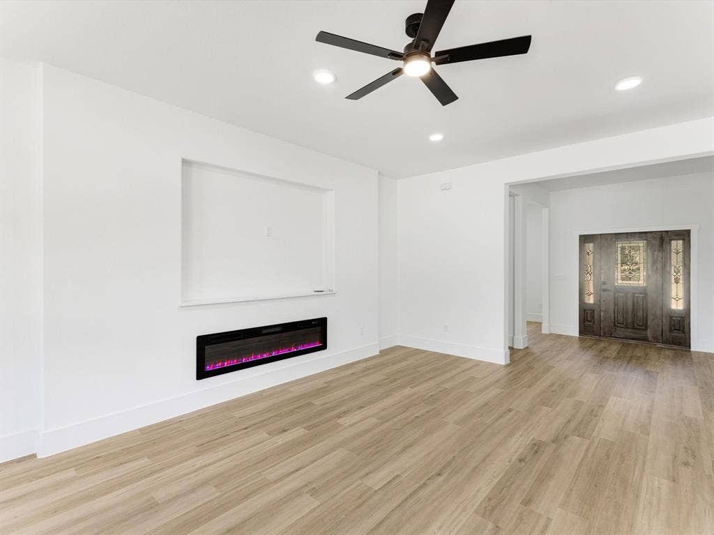 475 Loren Boyd Road, Combine, TX 75159 Interior space featuring wood-finish flooring, a wall-mounted electric fireplace, recessed lighting, a ceiling fan with integrated lighting, and a front entry door with glass panel detailing