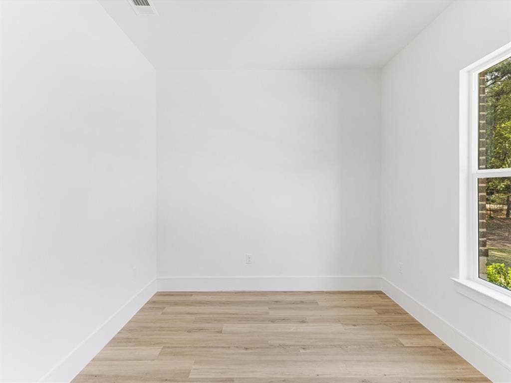 475 Loren Boyd Road, Combine, TX 75159 Neutral interior space featuring crisp white walls, wood-finish flooring, and a single-pane window