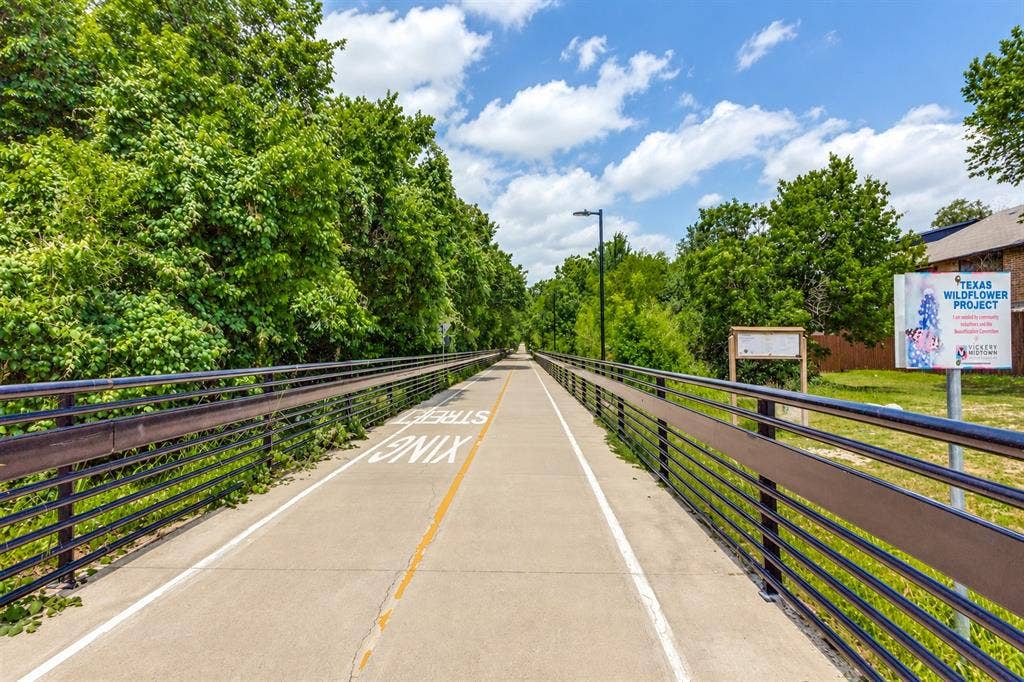 7525 Holly Hill Drive, #3, Dallas, TX 75231 Paved multi-use trail featuring metal railings, overhead lighting, and mature perimeter trees
