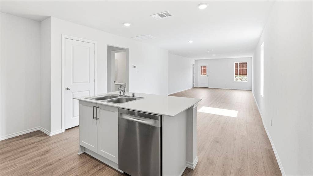 Open-concept living area featuring wood-finish flooring, recessed lighting, and white interior paint