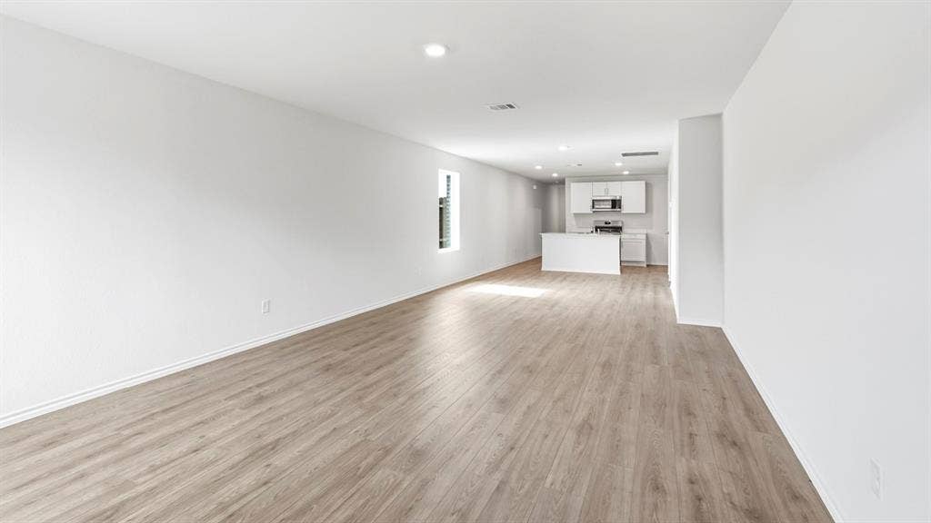 Open-concept layout with wood-finish flooring, recessed lighting, and a modern kitchen