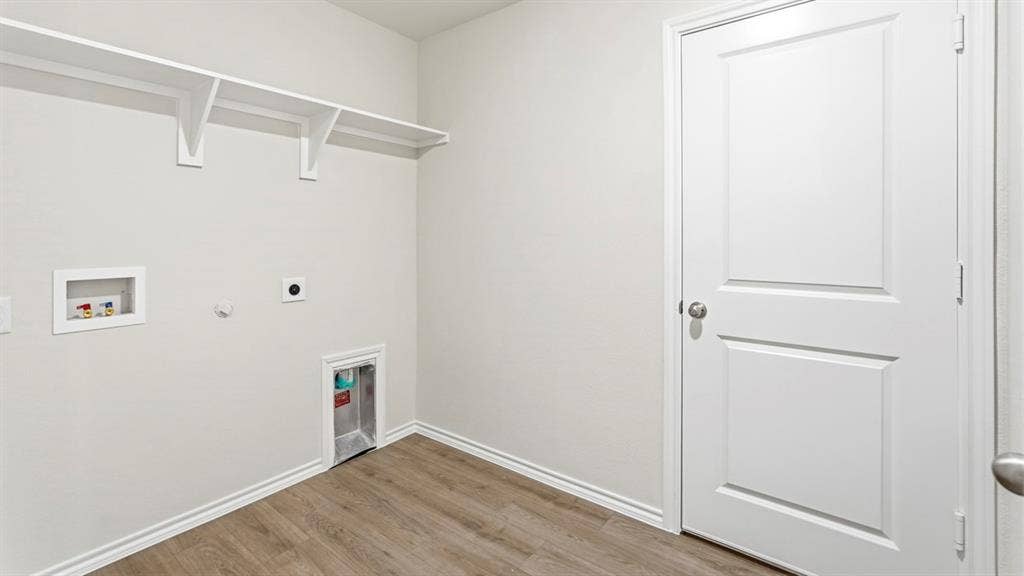 Utility space featuring wood-finish flooring, white walls, and built-in shelving