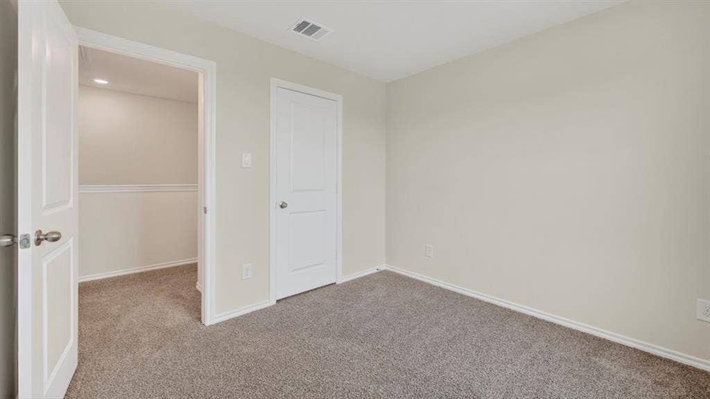 Neutral-toned room with plush carpeting and light-colored walls