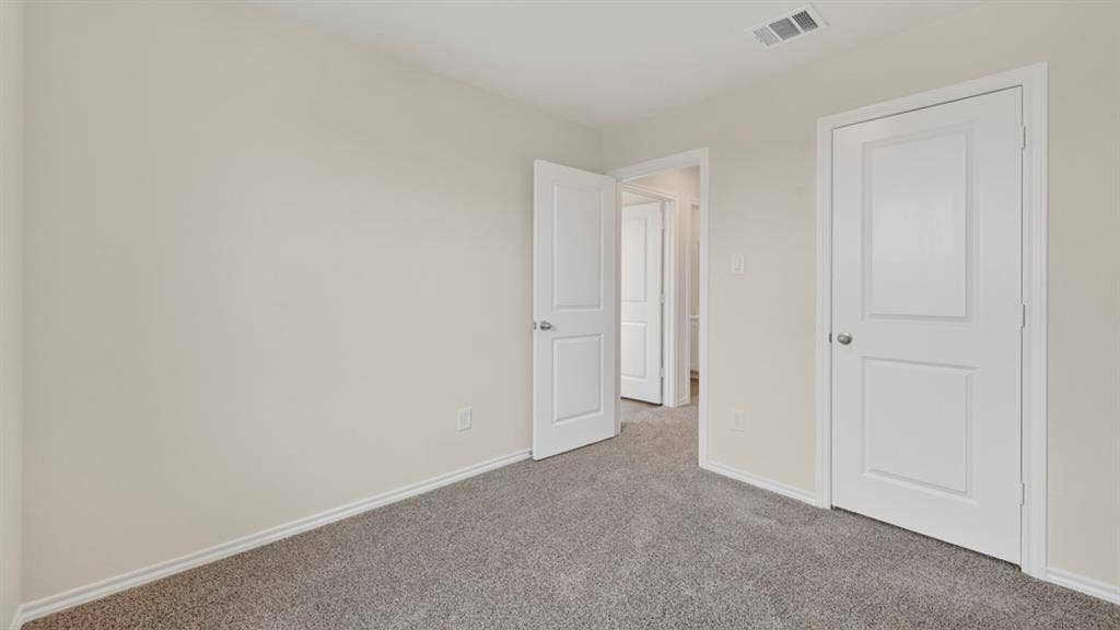 Neutral wall tones complement the gray carpeted flooring