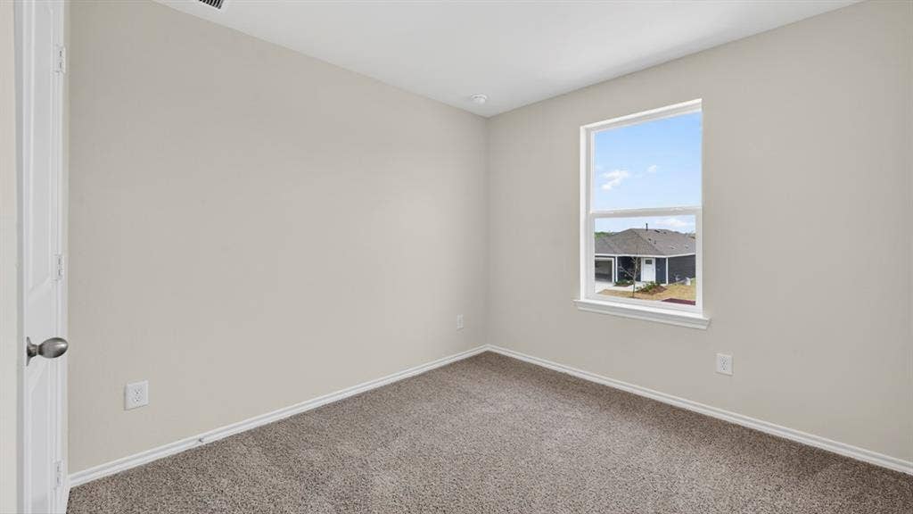 Neutral-toned room featuring a single window, light gray walls, gray carpet, and white trim