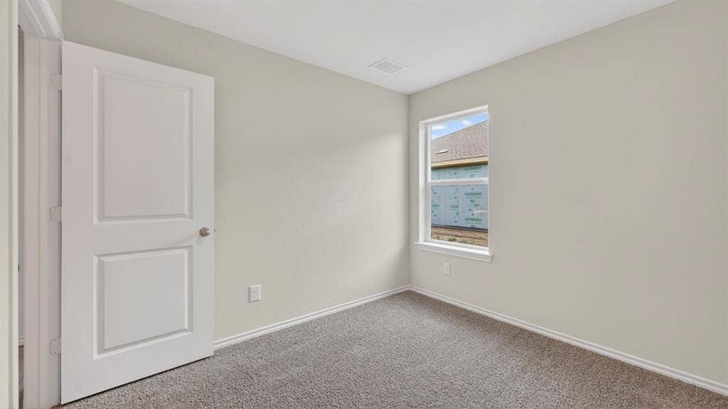 2825 Selfridge Lane, Forney, TX 75126 Neutral wall paint, gray carpeting, a two-panel interior door, and a single-pane window