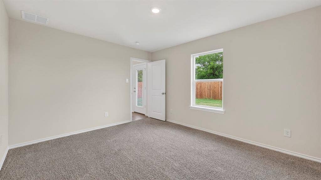 2825 Selfridge Lane, Forney, TX 75126 Neutral wall paint, carpet flooring, a window with exterior visibility, and a solid door with a frosted glass panel