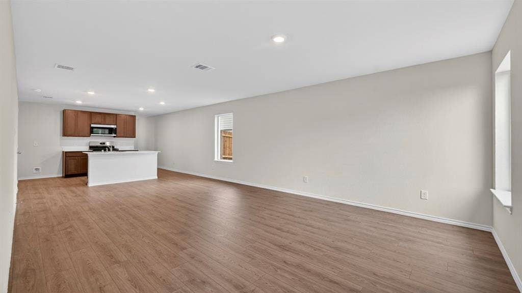 2825 Selfridge Lane, Forney, TX 75126 Open-concept living space featuring wood-finish flooring, recessed lighting, and a kitchen island with a white countertop