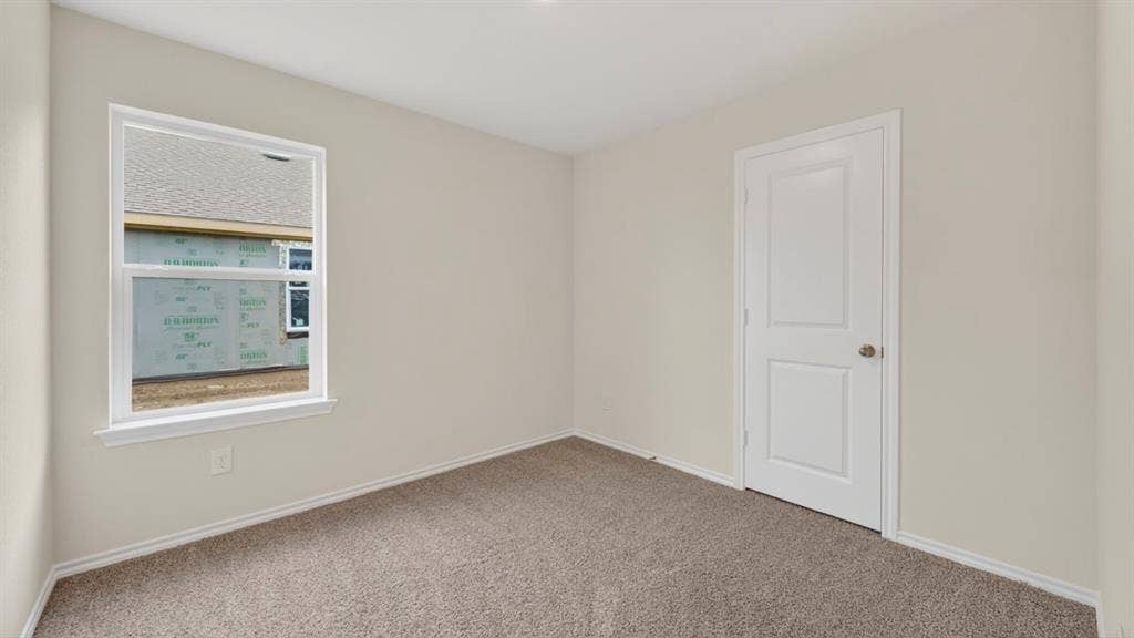 2825 Selfridge Lane, Forney, TX 75126 Neutral-toned carpeting, white interior door with polished hardware, white trim, and a white-framed window