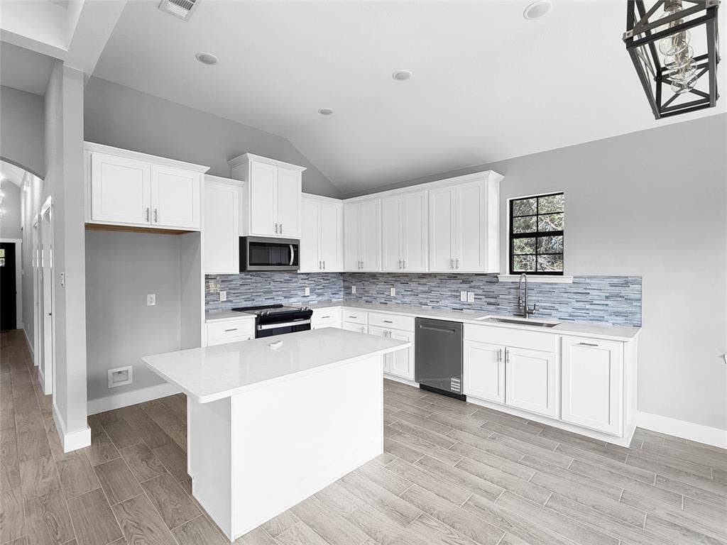 3025 Red Oak Drive, Granbury, TX 76048 Kitchen featuring white shaker-style cabinetry, quartz countertops, multi-tonal linear tile backsplash, wood-finish flooring, and a center island