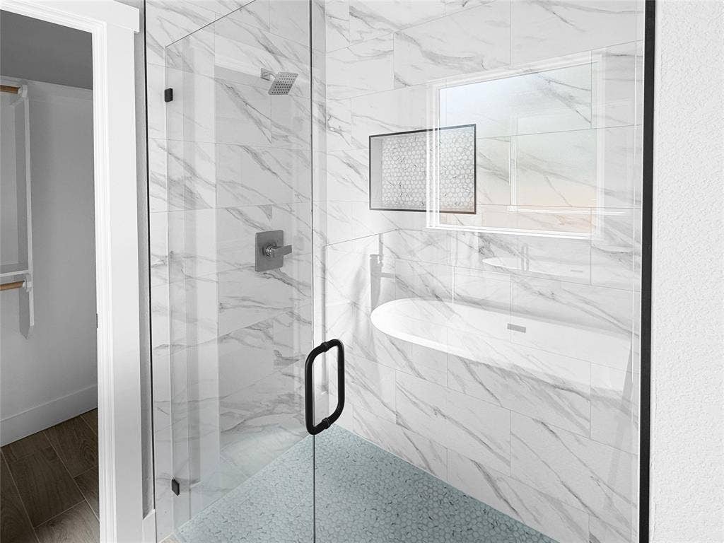 3025 Red Oak Drive, Granbury, TX 76048 Walk-in shower featuring glass enclosure, large-format tiled walls with stone-pattern finish, pebble-texture flooring, integrated tiled niche, and matte black fixtures