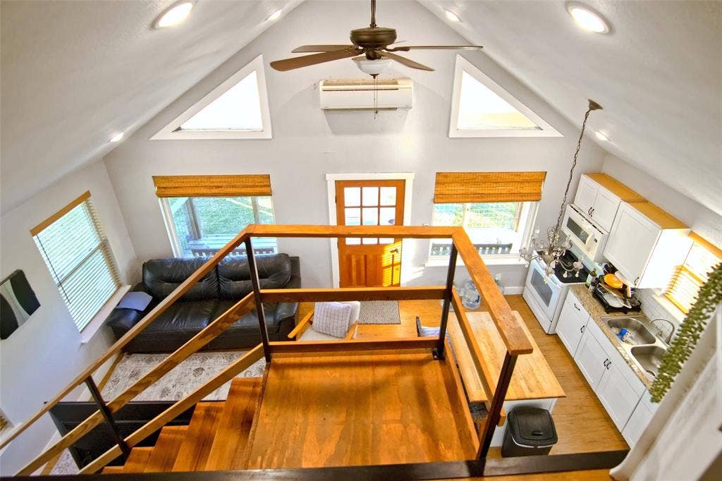325 & 321 Grassy Way, Elm Mott, TX 76640 Vaulted ceiling with a ceiling fan, recessed lighting, wood-finish stairs with a wooden railing, multi-pane entry door, and white cabinetry
