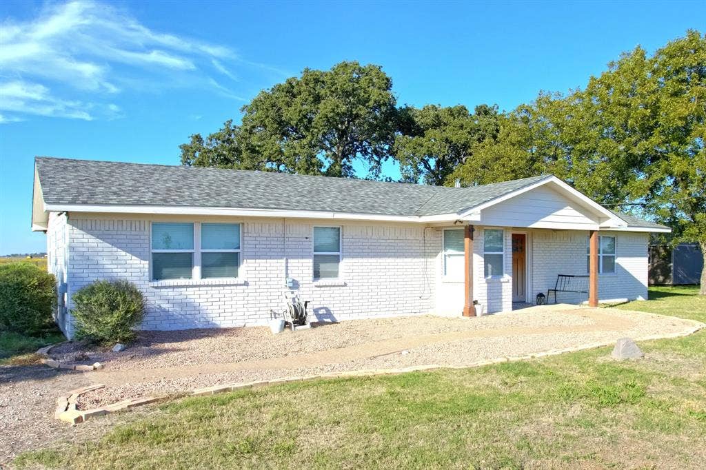 325 & 321 Grassy Way, Elm Mott, TX 76640 Single-story Ranch-Style, brick exterior featuring a covered front porch, asphalt shingle roof, and decorative wooden support posts