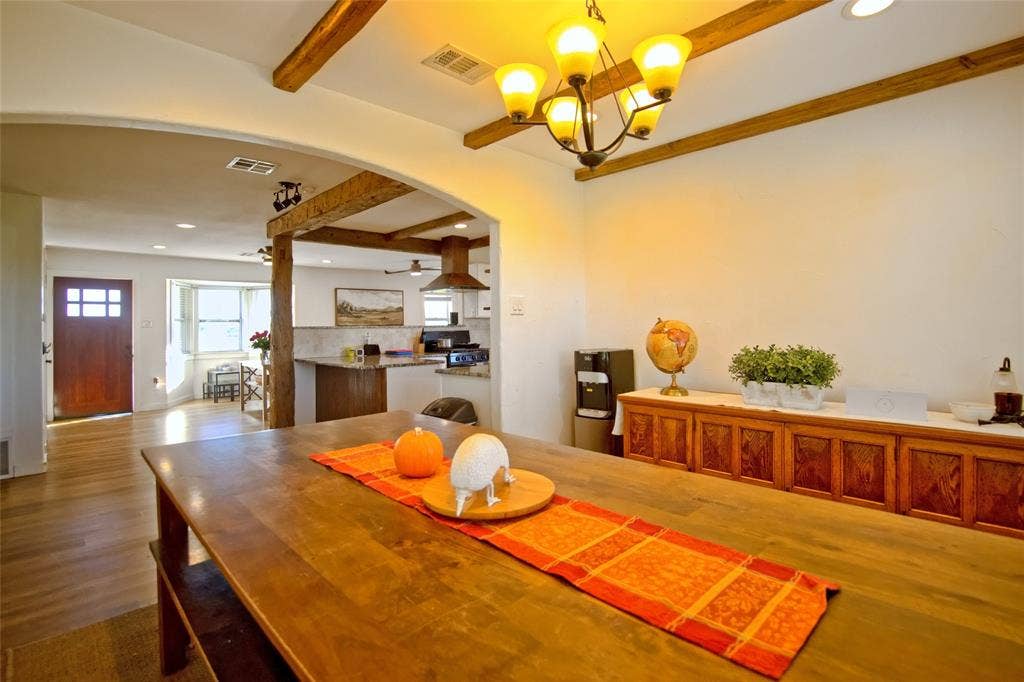 325 & 321 Grassy Way, Elm Mott, TX 76640 Exposed timber ceiling beams, wood-finish flooring, multi-light chandelier, and arched architectural detailing