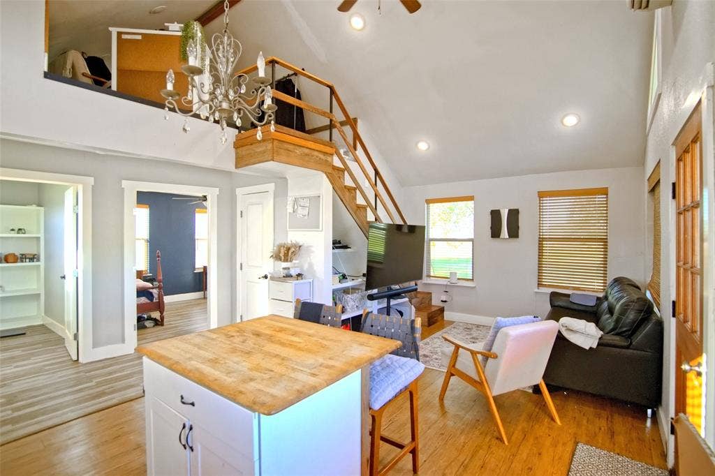 325 & 321 Grassy Way, Elm Mott, TX 76640 Vaulted ceiling featuring recessed lighting, a wooden loft structure with integrated staircase, chandelier, kitchen island with wood-finish surface, and wood-finish flooring
