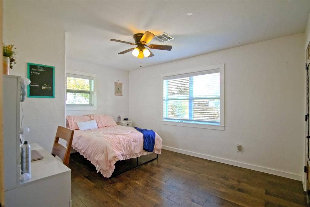 325 & 321 Grassy Way, Elm Mott, TX 76640 Room featuring wood-finish flooring, dual windows with blinds, and a central ceiling fan with integrated lighting