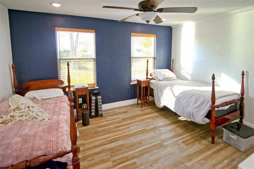 325 & 321 Grassy Way, Elm Mott, TX 76640 Wood-finish flooring, accent wall, ceiling fan, and dual windows