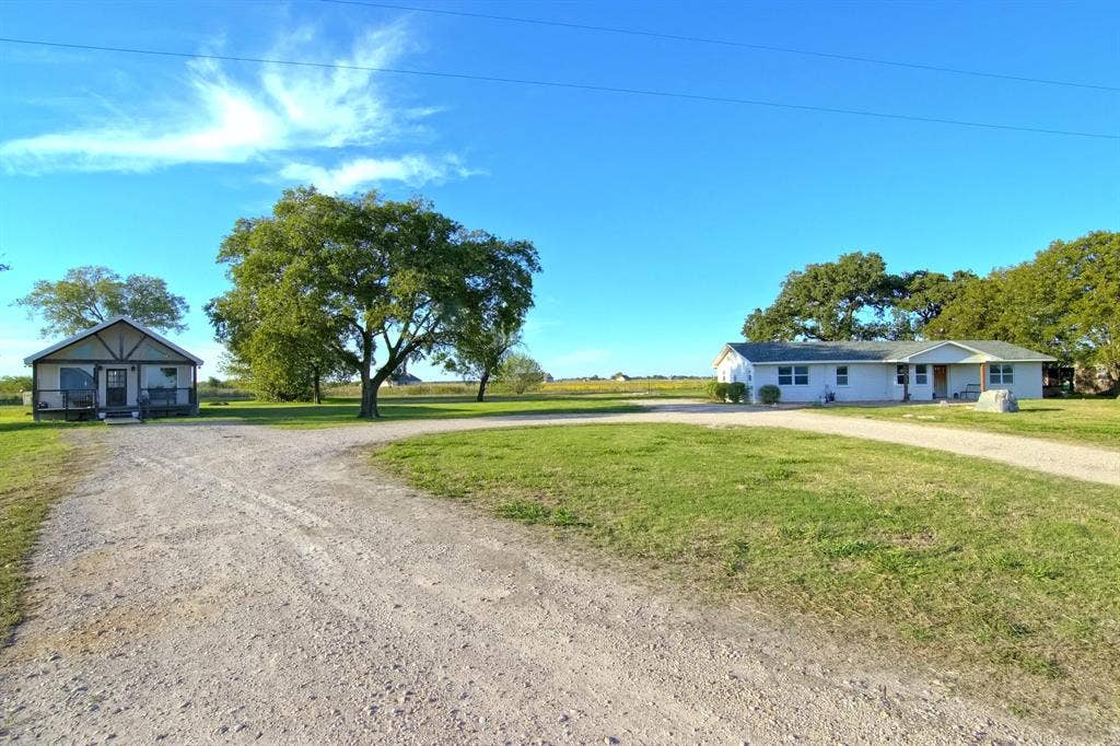 325 & 321 Grassy Way, Elm Mott, TX 76640 Expansive acreage featuring two detached residences, gravel driveway, mature trees, and open green space