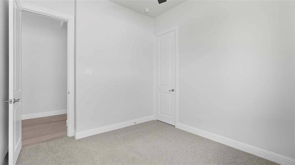 Interior space featuring neutral wall tones, plush wall-to-wall carpeting, and two-panel interior doors with satin nickel hardware