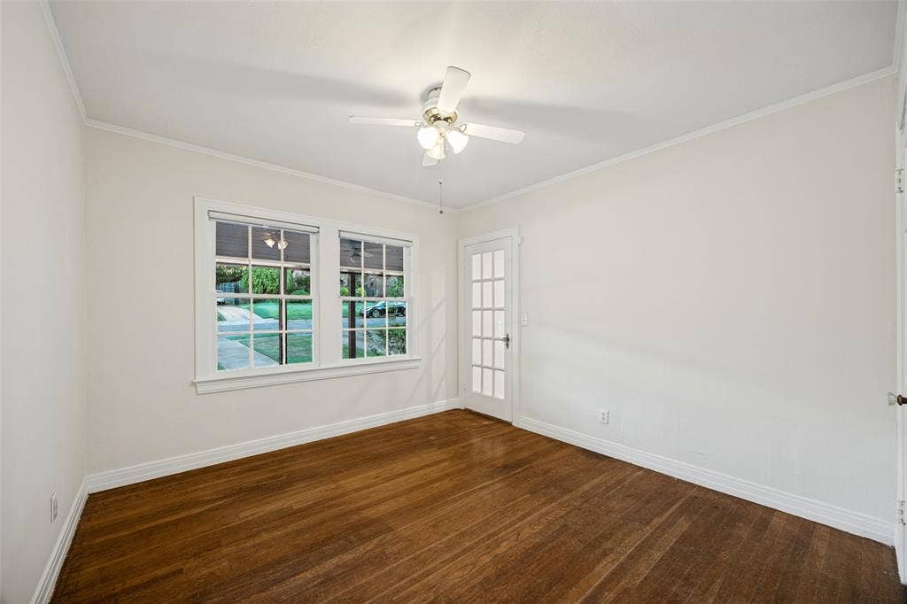 7011 Hammond Avenue, Dallas, TX 75223 Room interior featuring wood-finish flooring, white walls, a ceiling fan with integrated lighting, dual-pane windows, and a glass-paneled exterior door