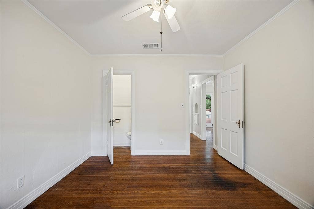 7011 Hammond Avenue, Dallas, TX 75223 Room featuring wood-finish flooring, white six-panel interior doors, and a ceiling-mounted light fixture with a fan