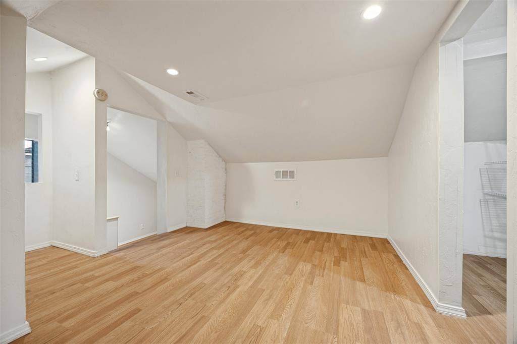 7011 Hammond Avenue, Dallas, TX 75223 Sloped ceilings featuring recessed lighting and wood-finish flooring