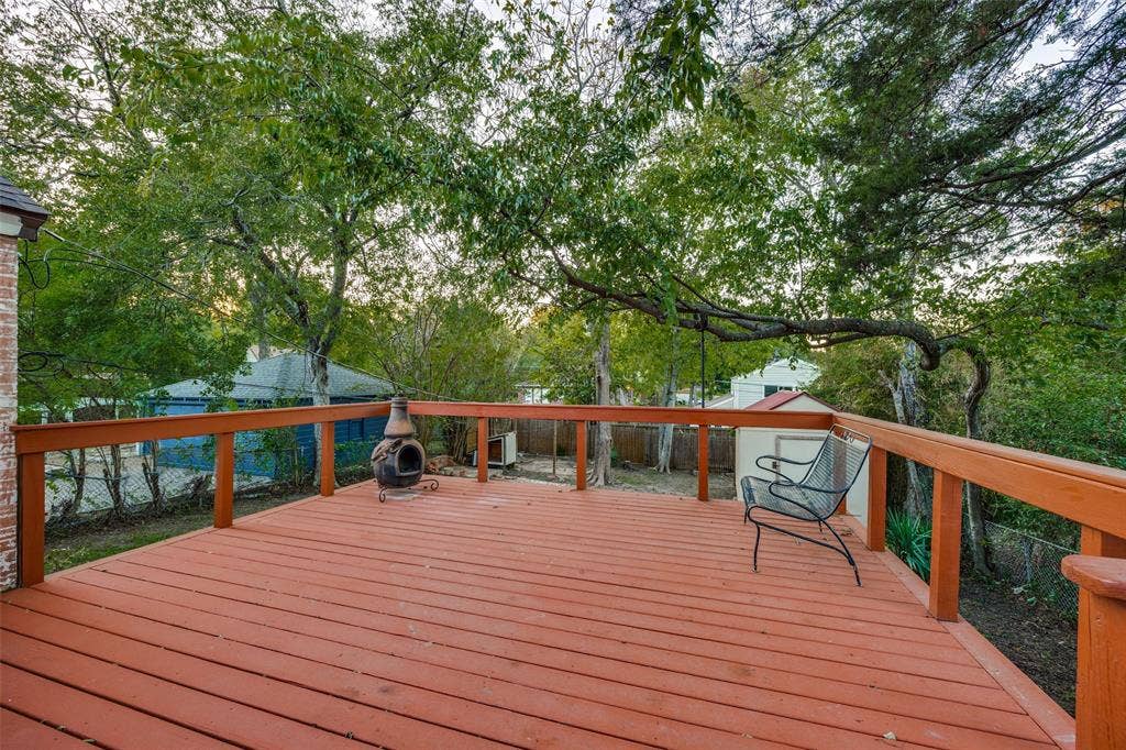 7011 Hammond Avenue, Dallas, TX 75223 Elevated wood-plank deck featuring a perimeter railing and mature tree canopy