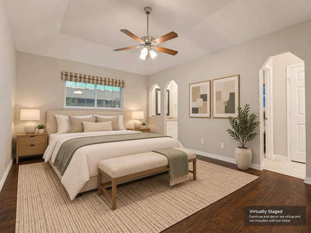 900 Lexington Drive, Plano, TX 75075 Tray ceiling featuring a central brushed-nickel ceiling fan with integrated lighting, wood-finish flooring, and arched architectural wall cutouts