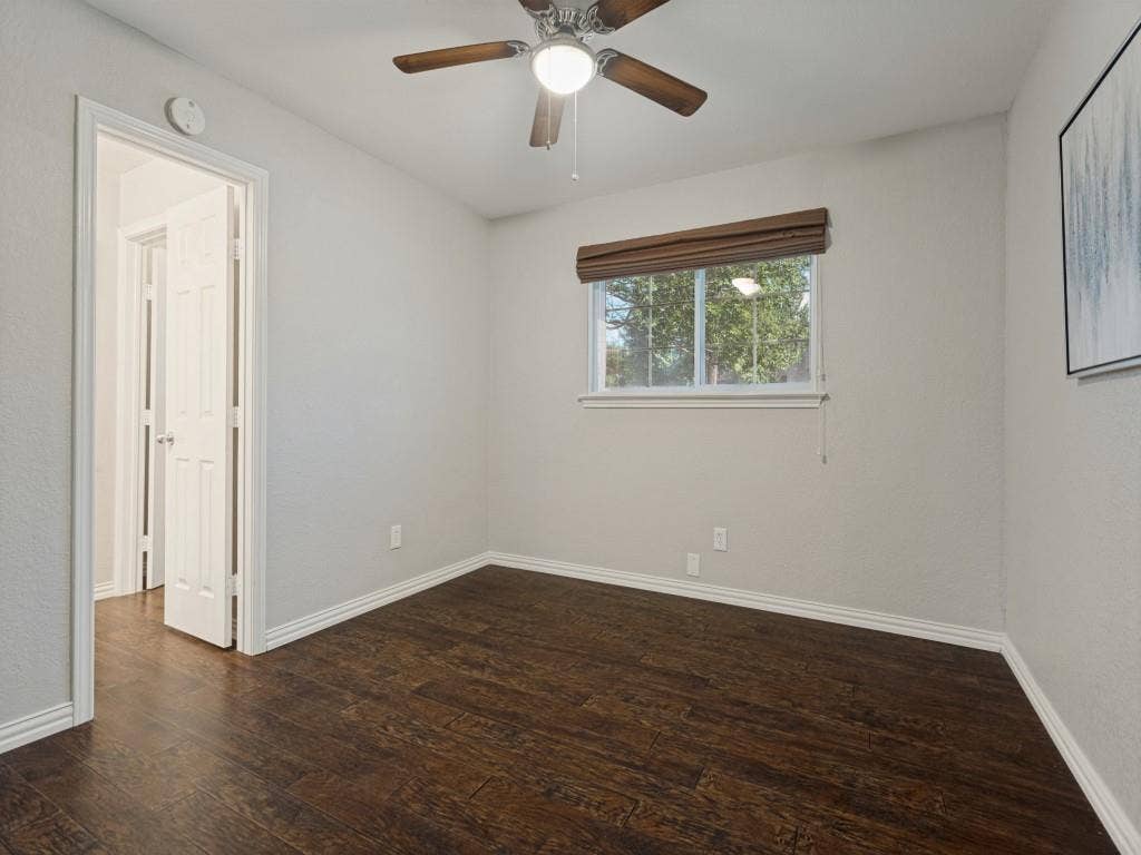 900 Lexington Drive, Plano, TX 75075 Room featuring wood-finish flooring, a ceiling fan with integrated lighting, a sliding window with a roller shade, and a six-panel door
