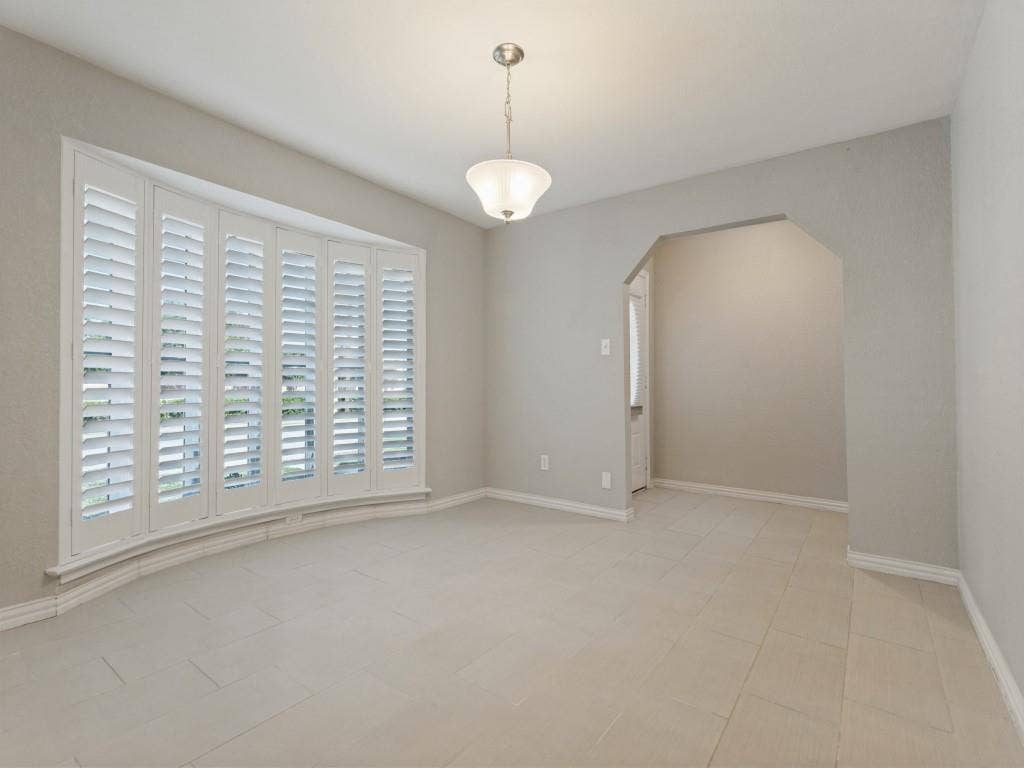 900 Lexington Drive, Plano, TX 75075 Bay window featuring white plantation shutters, neutral tile flooring, and a pendant light fixture with a bell-shaped glass shade