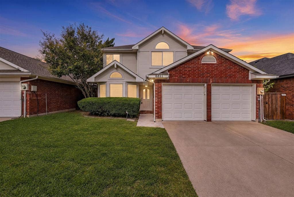 6821 Douglas Creek, Plano, TX 75023 Two-story residence featuring a brick and siding facade, a double-car garage, a bay window, and arched architectural detailing