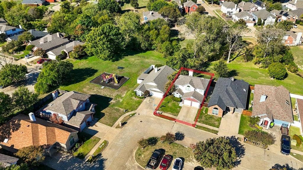 6821 Douglas Creek, Plano, TX 75023 Aerial view of a residential property featuring a pitched shingle roof, integrated two-car garage, concrete driveway, and a fenced backyard